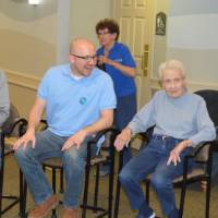 Volunteers and seniors enjoy conversation with one another.